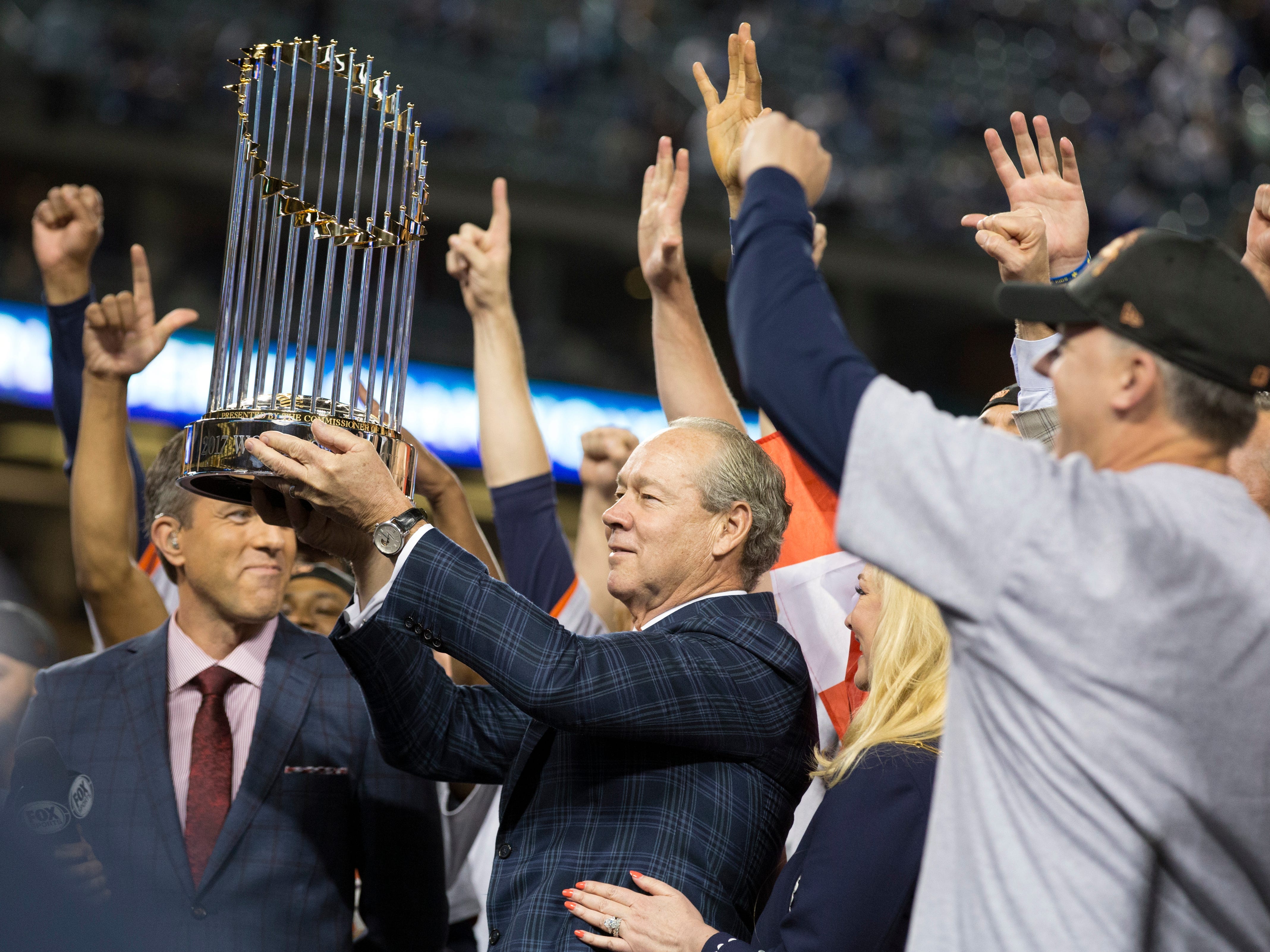 Houston Astros owner Jim Crane hoists the Commissioner's Trophy after the Astros defeated the Los Angeles Dodgers