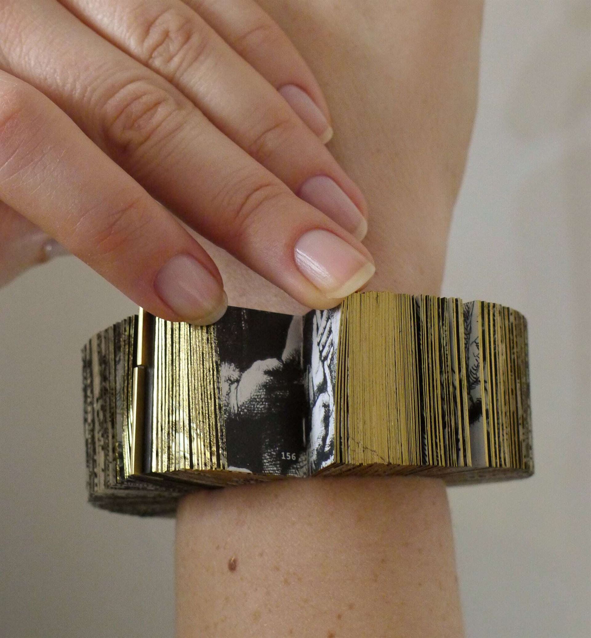 A photo of a bracelet made of thousands of printed pages