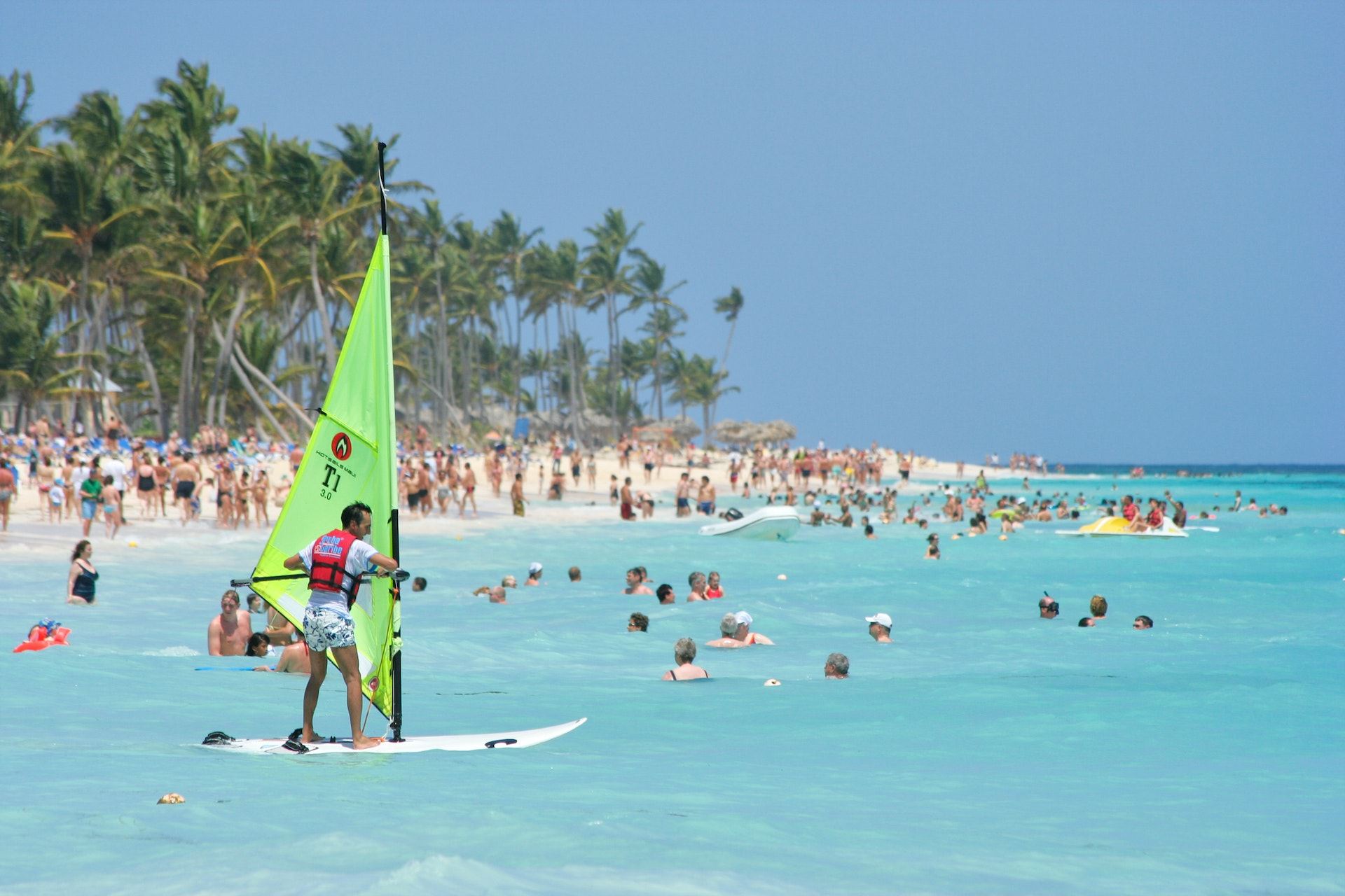 Tourist learning to windsurf at a busy Punta Cana beach