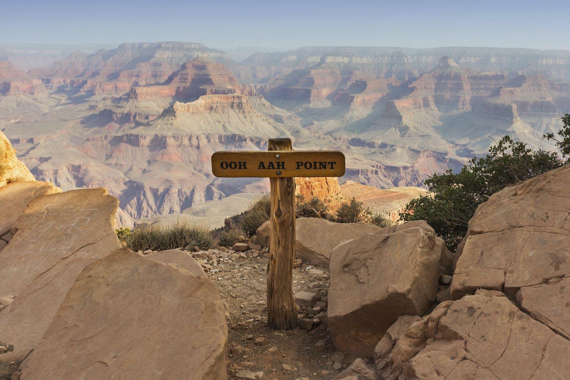The wooden Ooh Aah Point sign in the centre of the picture, which overlooks the vast Grand Canyon