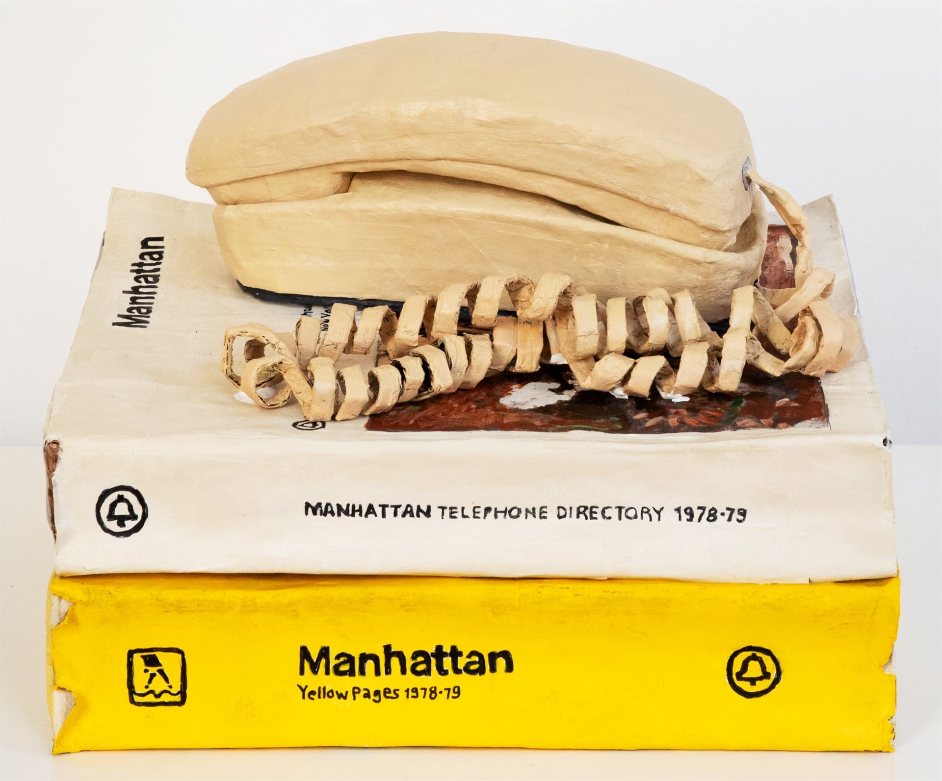 A photo of paper mache phone books and a phone