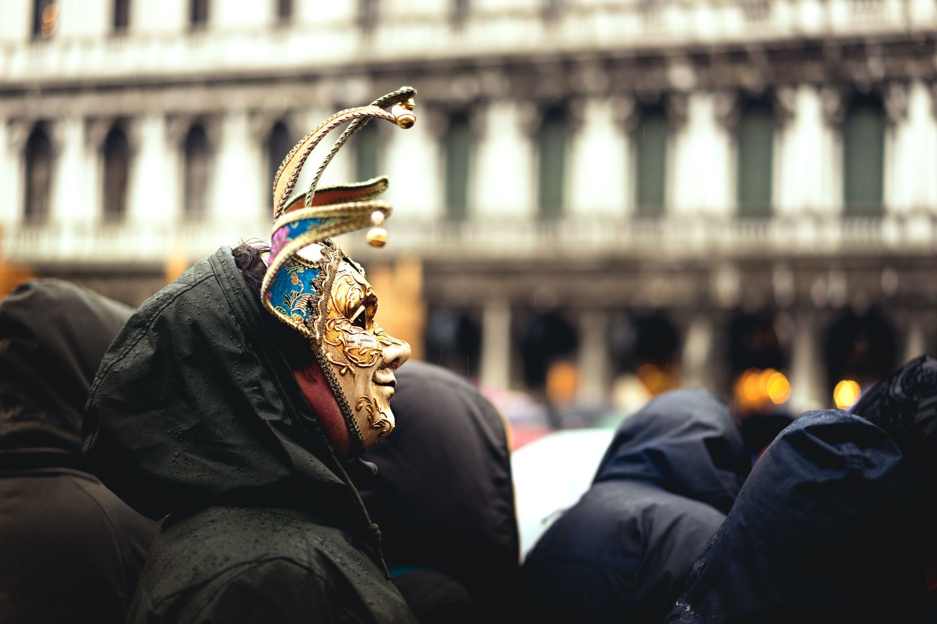 A man wearing a venetian mask in a crowd during the Venice Carnival